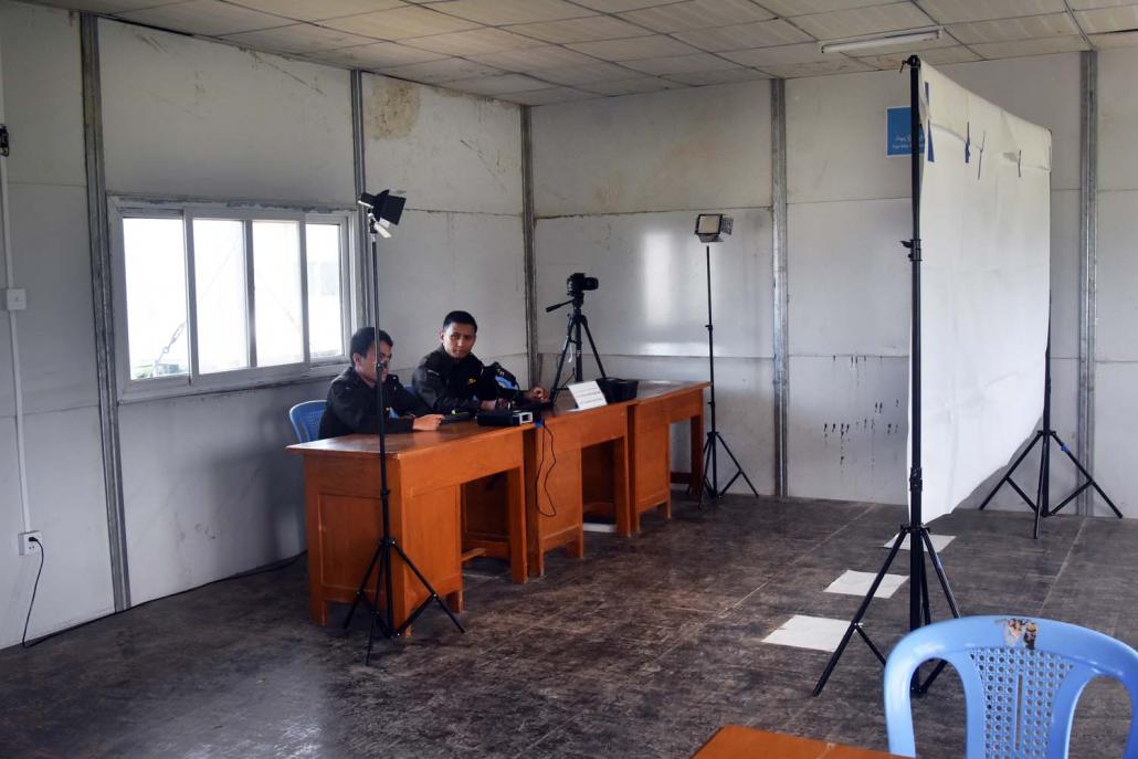 Immigration officials wait at the Ngakhuya reception centre for refugees. (Oliver Slow | Frontier)