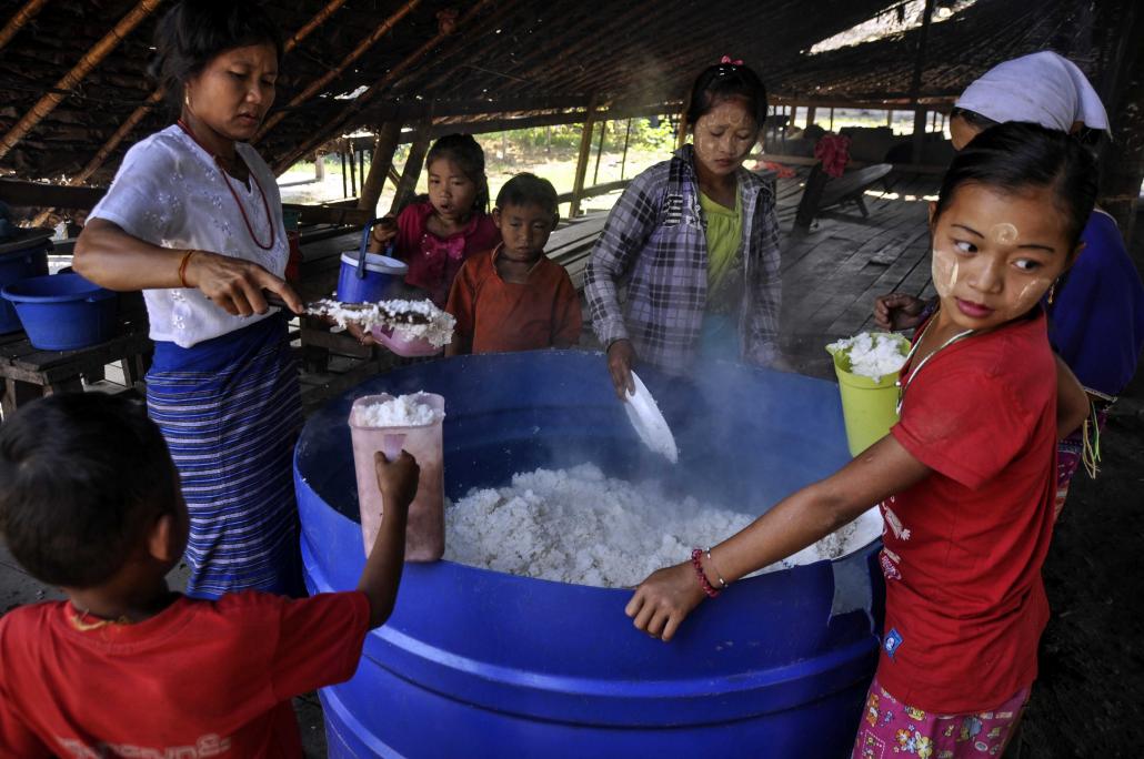 A woman distributes steamed rice to IDPs at Myaing Gyi Ngu. Because of the Buddhist prohibition on killing, residents are not supposed to eat meat, although this rule is not always observed in private. (Kyaw Lin Htoon | Frontier)