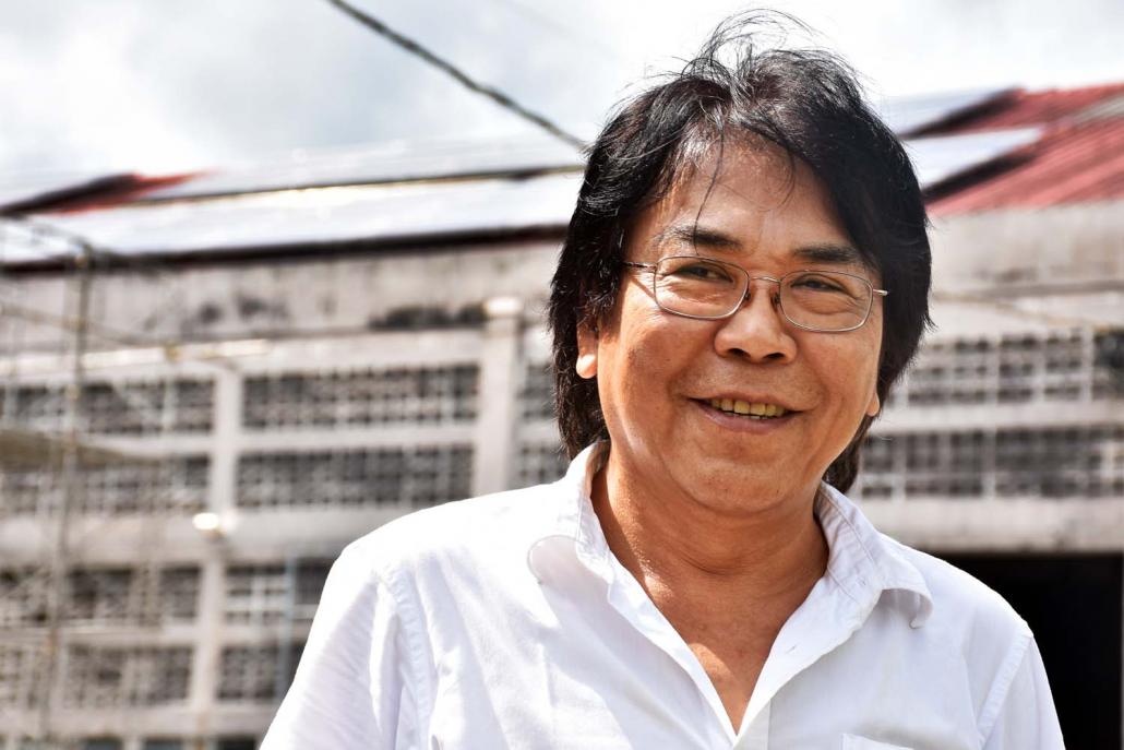 U Tin Sein stands in front of the rooftop solar system at his canning factory in Yangon's Dagon Seikkan Township. (Steve Tickner | Frontier)