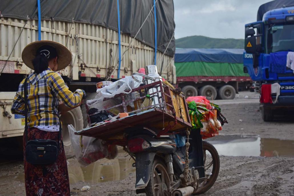 A migrant from Monywa sells snacks and drinks from the back of her motorbike at the 105 Mile trade zone south of Muse. (Kyaw Lin Htoon | Frontier)