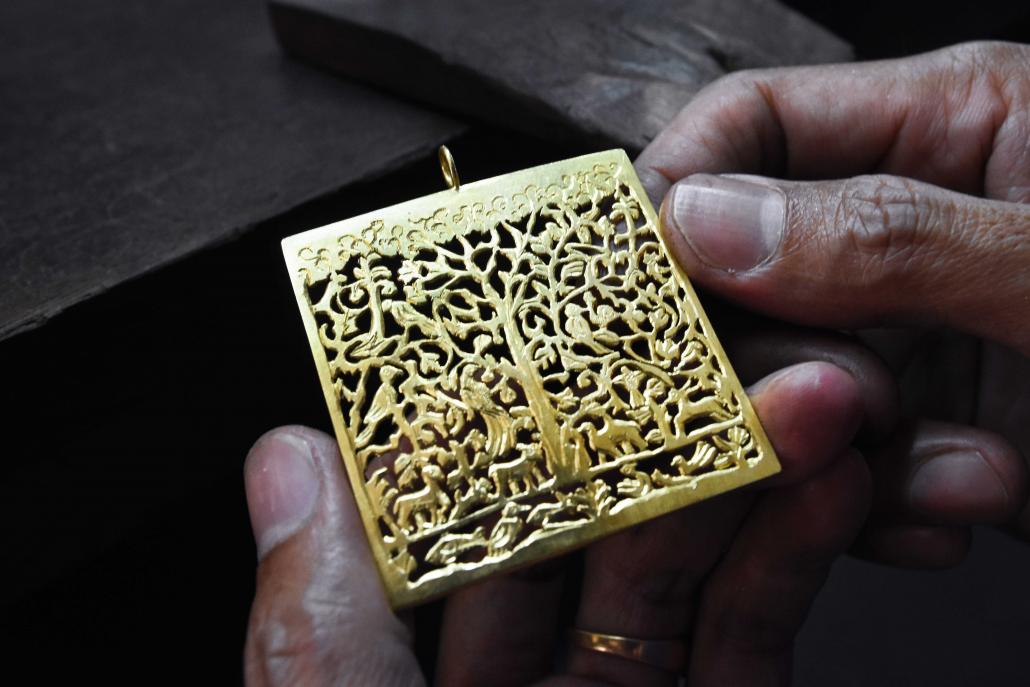 A participant at a jewellery workshop run by NGO Turquoise Mountain holds a piece described as 'the tree of life' design. (Steve Tickner | Frontier)