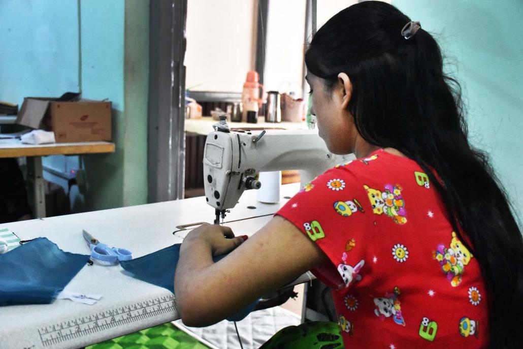 A Rohingya girl sews clothes at the Vocational School for Women in Yangon's Bahan Township. (Steve Tickner | Frontier)