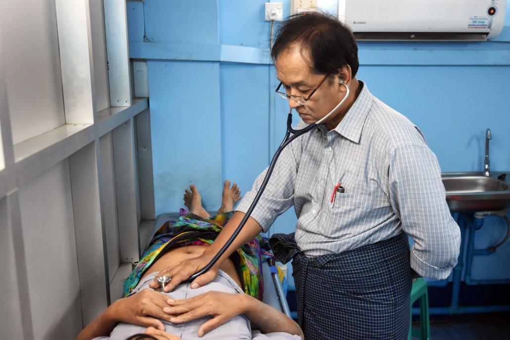 Dr Myint Thein treats a patient at the Hantharwaddy U Win Tin Foundation charity clinic in Yangon. (Steve Tickner | Frontier)