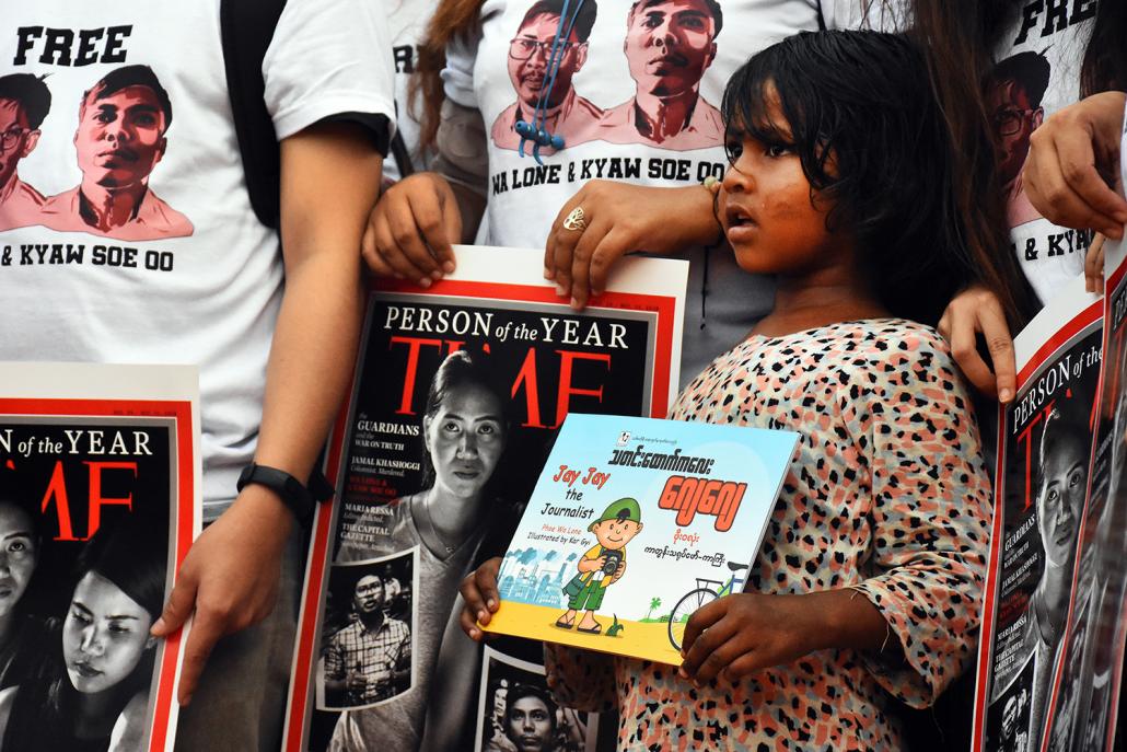 A child holds a copy of Jay Jay the Journalist, a recently published children's book about a schoolboy reporter written by Ko Wa Lone from inside Insein Prison. (Steve Tickner | Frontier)