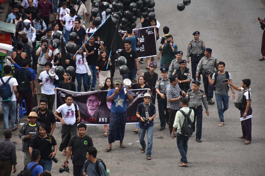 Police escort demonstrators calling for the release of journalists Wa Lone and Kyaw Soe Oo through the streets of Yangon on September 1. (Steve Tickner | Frontier)