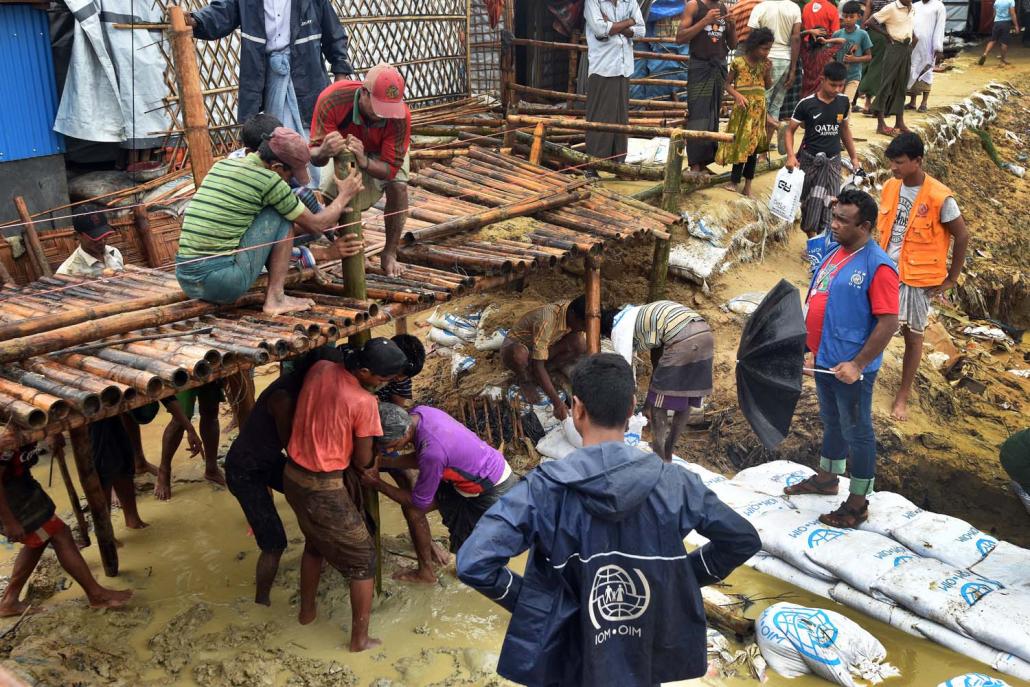 A group of men work to erect a bridge in one of the camps, ahead of heavy monsoon rains expected in the coming months. (Steve Tickner | Frontier)