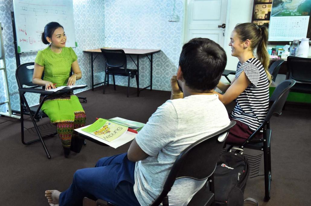 Ma Moe Chit teaches Burmese to two foreign students at the Moe Myanmar Language Centre. (Steve Tickner | Frontier)