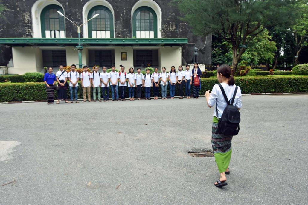 Students pose for a photo in front of the Convocation Hall at Yangon University. The university forbids the use of professional cameras on the campus. (Steve Tickner | Frontier)