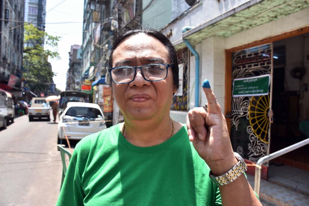 A voter shows an inked finger outside a polling station in Kyauktada Township. (Steve Tickner | Frontier)