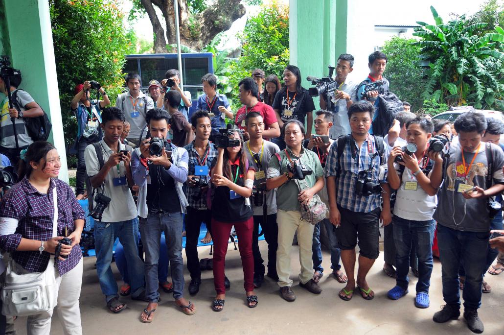 Media wait outside a courtroom in Bahan Township during the defamation trial of two journalists. (Steve Tickner | Frontier)