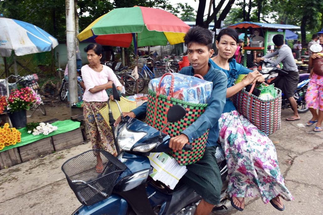 Shoppers at a market in South Dagon Township return home by motorbike. (Steve Tickner | Frontier)