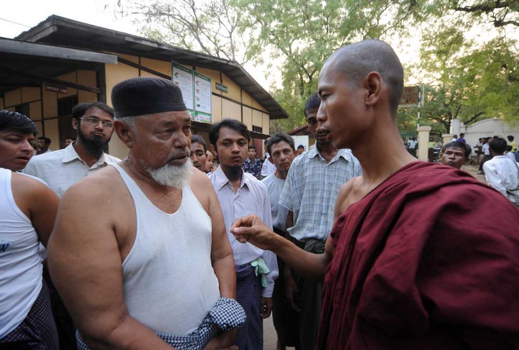 A Buddhist monk and a Muslim man talk at a state school in Meiktila where Muslim residents had taken refuge following deadly communal conflict in March 2013. (Steve Tickner | Frontier)