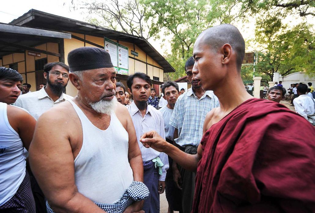 A Buddhist monk speaks with displaced Muslims taking refuge in a school in Meiktila in the aftermath of communal rioting in 2013. (Steve Tickner | Frontier)