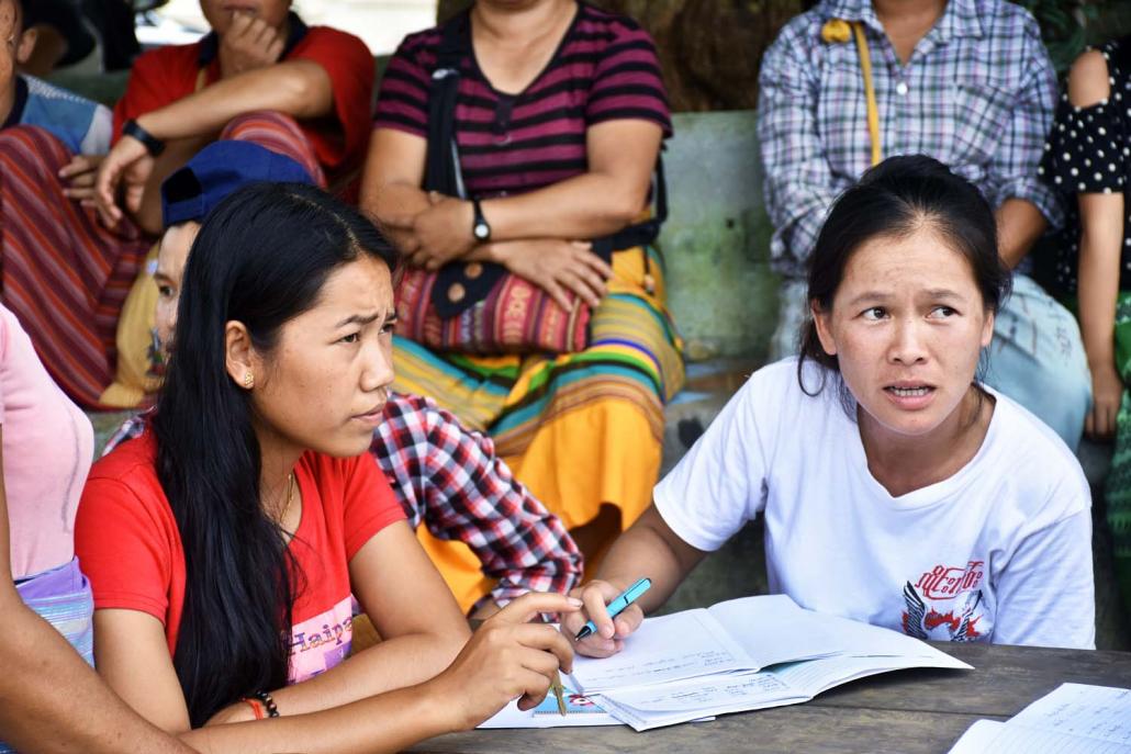 Volunteers help residents sheltering at a monastery in Mong Tin village, Kutkai Township, after they were displaced from neighbouring Kone Sar village by Tatmadaw mortar fire on August 17, 2019. (Steve Tickner | Frontier)