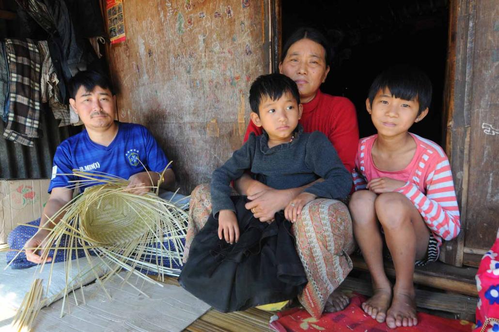 Nahpaw Grawng sits with his family in Woi Chyai. Like all IDP camps in areas outside government control, Woi Chyai has been cut off from international aid since April 2016. The 46-year-old weaves baskets for extra income. (Steve Tickner / Frontier)