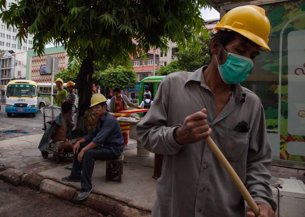 ရန်ကုန်မြို့ ဆူးလေဘုရားလမ်းပေါ်မှ ဆောက်လုပ်ရေးလုပ်သားများ။ ဓာတ်ပုံ - သိမ့်မွန်စိုး(ဂျေ)