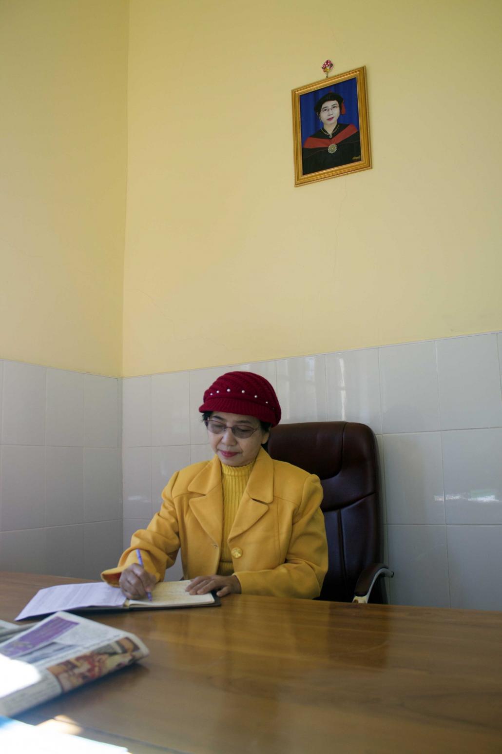 Hakha College principal Daw Aye Aye Ngun works in her office. (Jared Downing | Frontier)