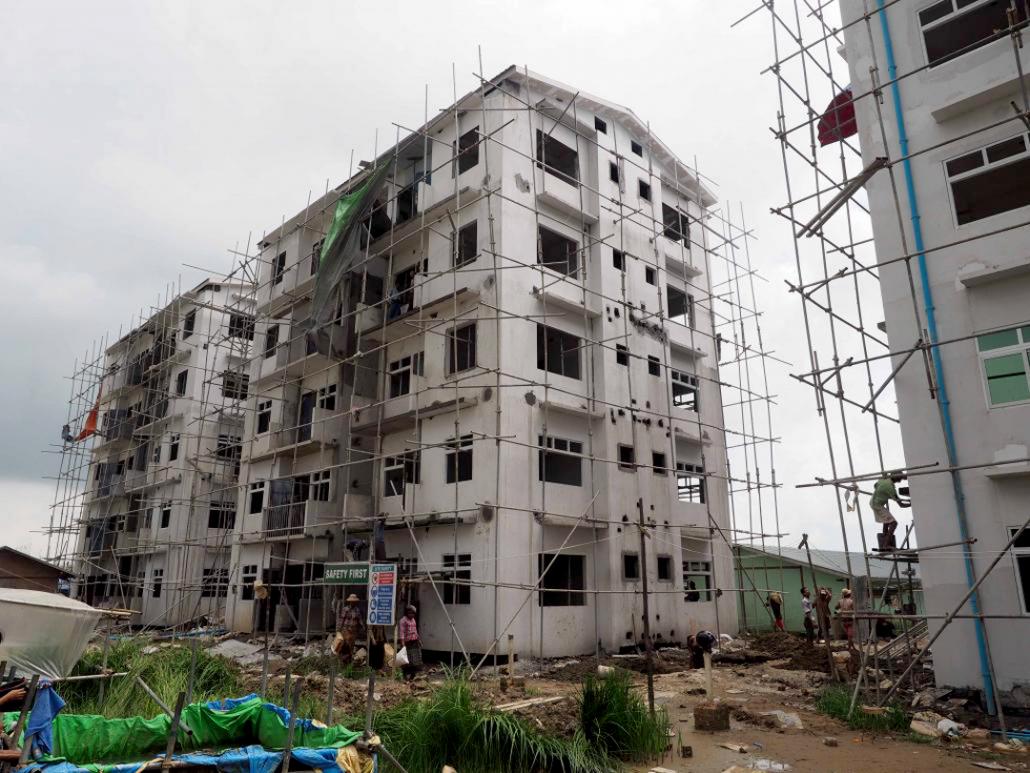 ဒဂုံဆိပ်ကမ်းမြို့နယ်ရှိ ရိုးမအိမ်ရာ ရှေ့ပြေးအစီအစဉ်၏ ဆောက်လက်စ တိုက်နှစ်လုံးကို တွေ့ရစဉ်။ ဓာတ်ပုံ - ကောနား မက်ဒေါ်နယ်