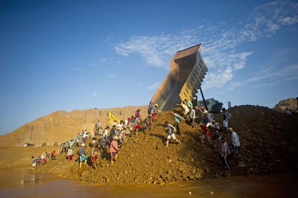 Freelance miners dig for raw jade stones in piles of waste rubble dumped by mechanical diggers next to a jade mine in Hpakant in October 2015. (AFP)