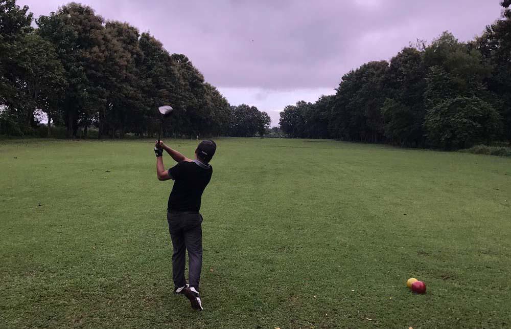 Nawng Ting tees off at a golf course in Myitkyina. (Daniel Combs | Frontier)