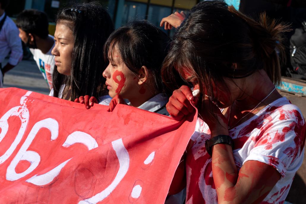 IDP youth at the event in Myitkyina on June 9 weep while holding banners to commemorate the resumption of the Kachin civil war eight years ago. (Phoe Shane | Frontier)