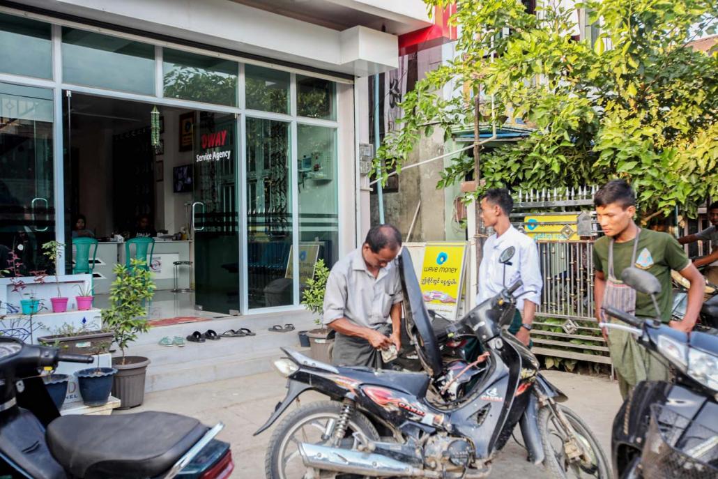 Mrauk-U residents come to the only shop in town where they can send and receive payments using mobile money service Wave Money. (Kyaw Lin Htoon | Frontier)