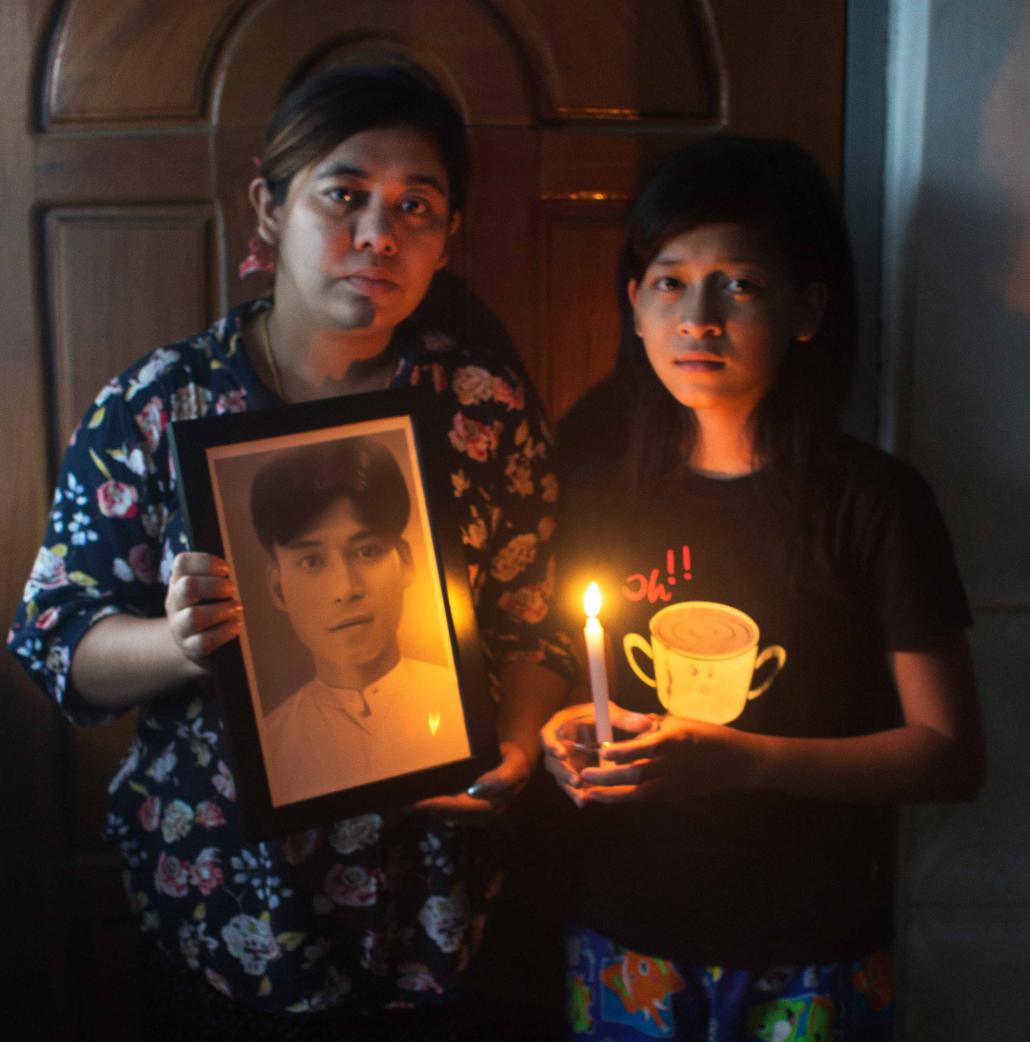The family of Aung Hlaing Win hold his portrait. (Letyar Tun / Framing the Transition)