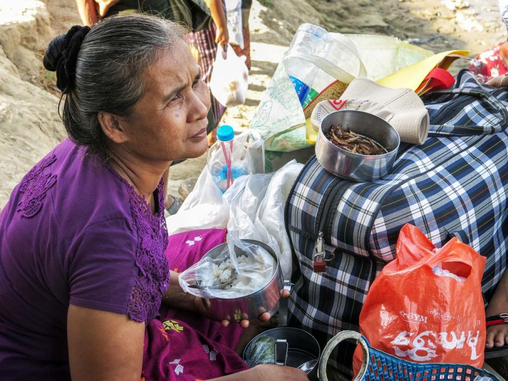 A woman eats breakfast at the jetty in Thabaung while she waits for a boat to take her to her village. (Kyaw Lin Htoon | Frontier)