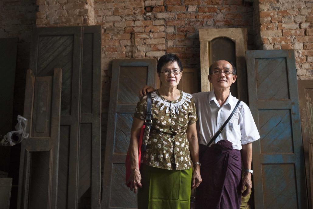 U Thein aung, right, and his wife stand inside their home on Yangon's 47th Street. The apartment has been in the family for about 90 years. (Theint Mon Soe aka J | Frontier)