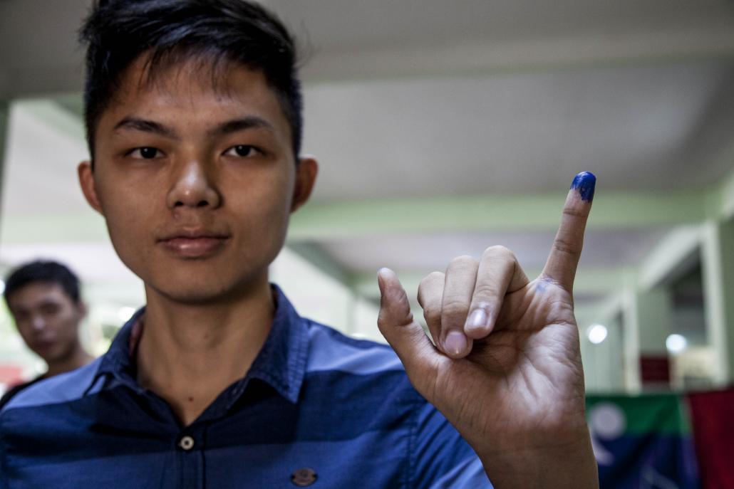 A voter shows off the indelible ink mark he was given after casting his ballot in Yangon’s Lanmadaw Township. (Theint Mon Soe — J | Frontier)