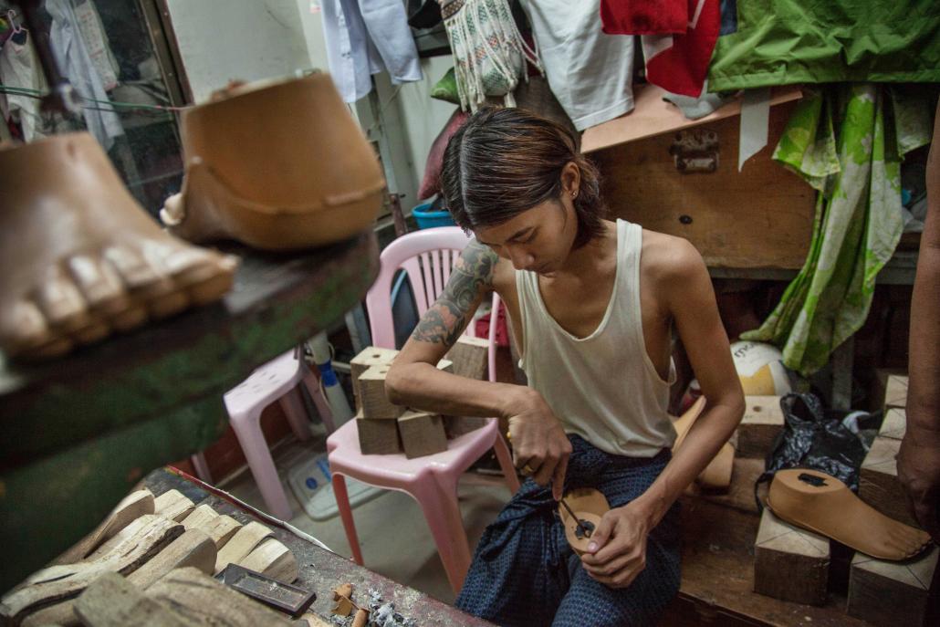 A man makes prosthetic limbs at a workshop operated by the Myanmar Physically Handicapped Association in Yangon. Experts say the current capacity for prosthetic care in Myanmar is less than a tenth of the total need. (Theint Mon Soe / Frontier)