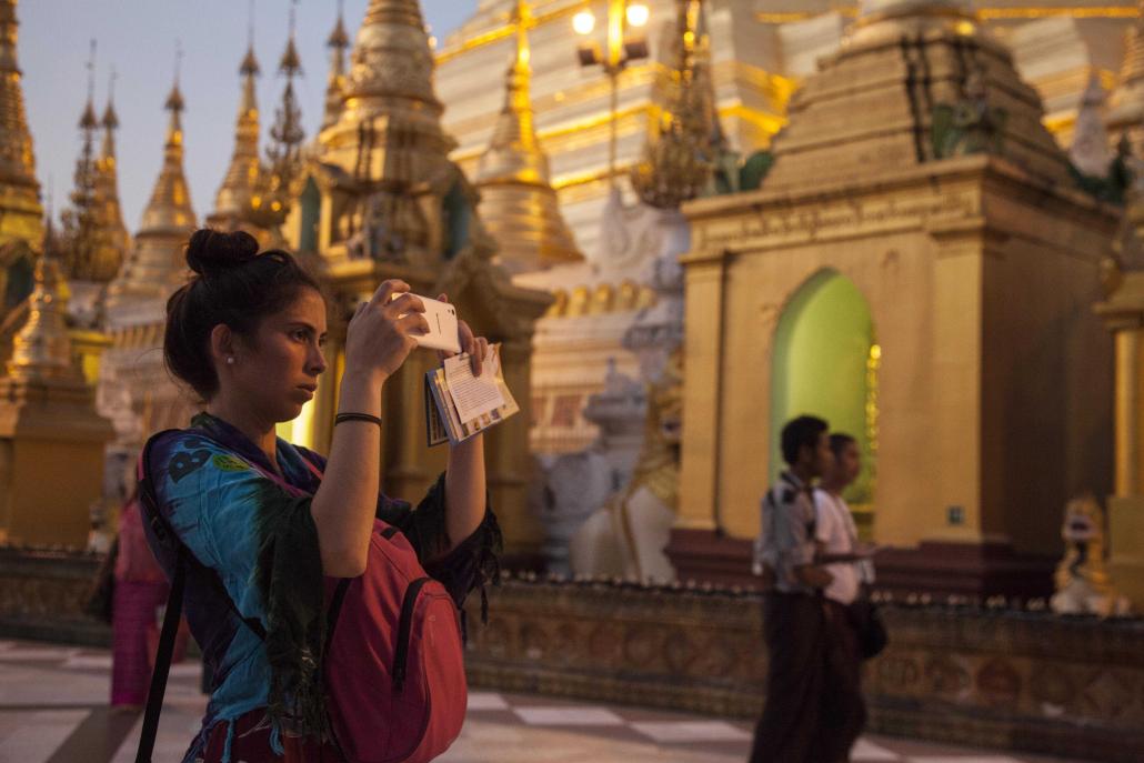 A tourist takes a photo on the grounds of Yangon's Shwedagon Pagoda. (Theint Mon Soe aka J | Frontier)