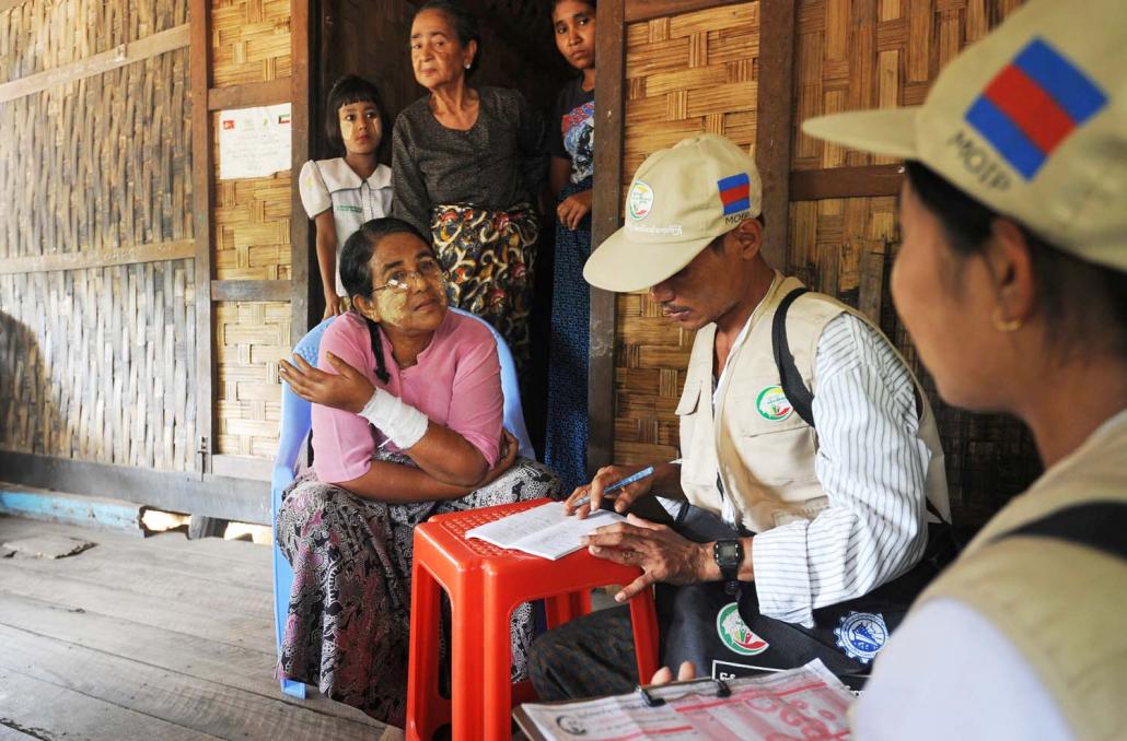 An ethnic Kaman woman (left) responds to census enumerators in Bumay village in Rakhine State on March 31, 2014. The data on ethnic populations from the census has not been released, contributing to confusion and controversy. (AFP)