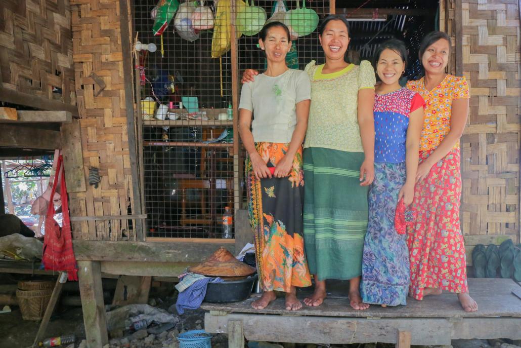 Members of the Triple C cooperative stand in front of one of the homes where they make the reusable sanitary pads, in northern Yangon (Victoria Milko | Frontier)