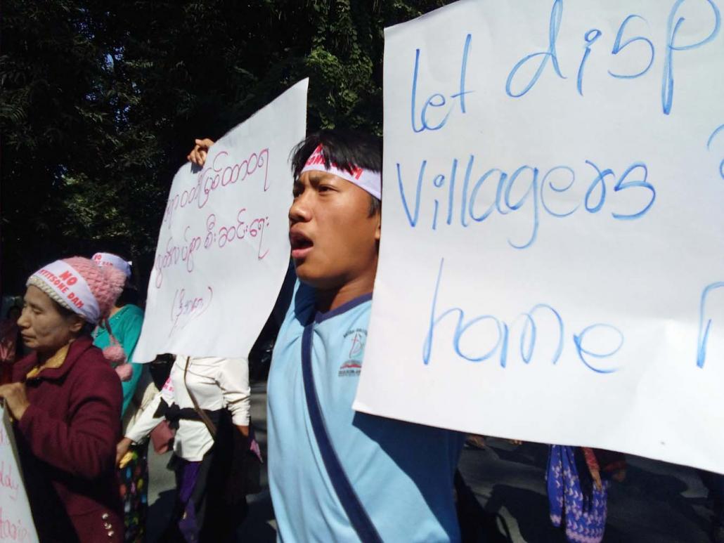 Demonstrators hold signs condemning the Myitsone Dam project during a protest in the Kachin State capital Myitkyina on February 7. (Emily Fishbein | Frontier)