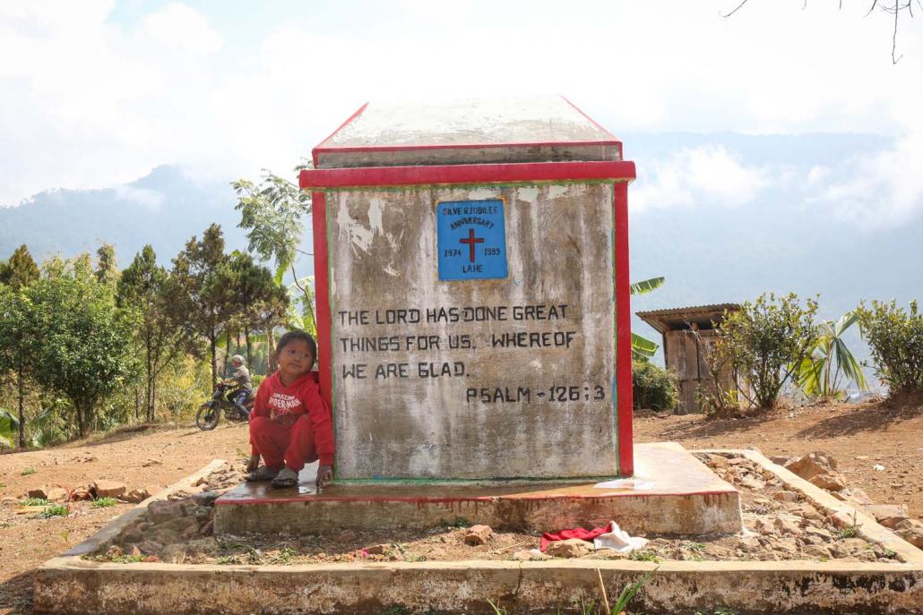 A child next to a church marker in Lahe. (Victoria Milko | Frontier)