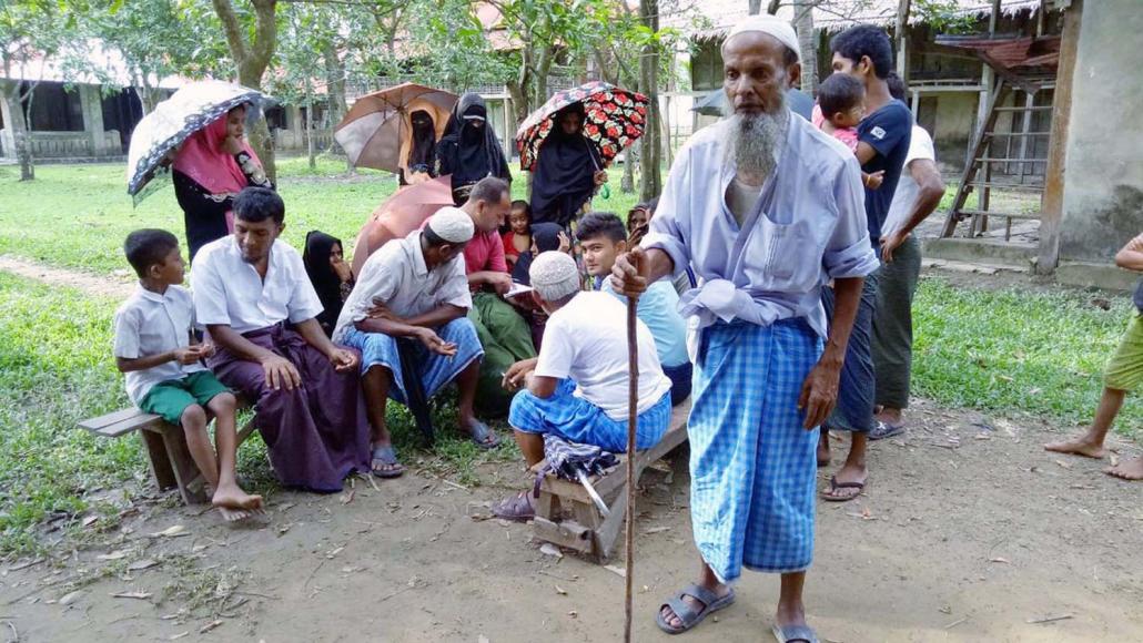 Rohingya villagers wait to be treated by a mobile clinic.