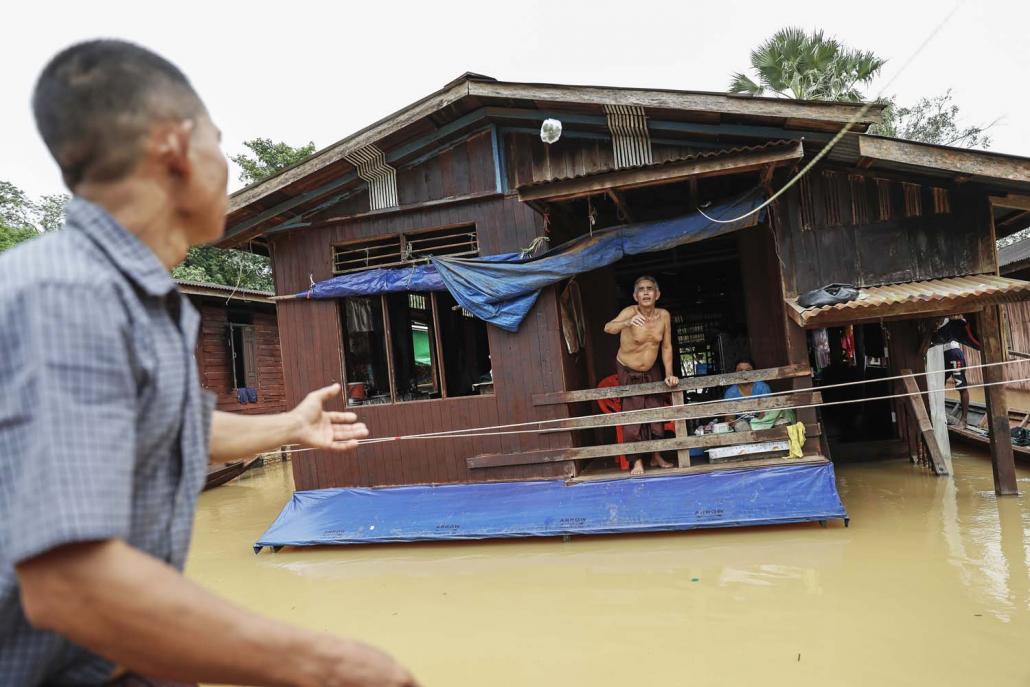 A resident of Nga Pyay Ma village in Kyaikmayaw Township gestures from the second floor of his flooded home on August 14. (Nyein Su Wai Kyaw Soe | Frontier)