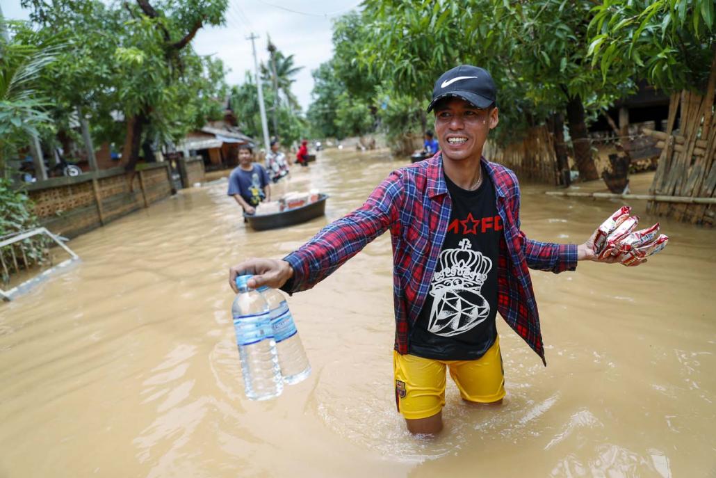 Volunteers distribute dried noodles to residents in the village of Han Gan, in Ye Township, on August 12, days before government relief arrived. (Nyein Su Wai Kyaw Soe | Frontier)