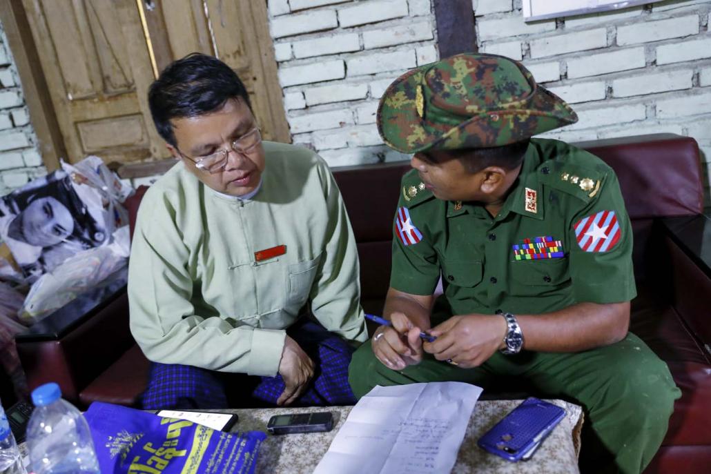 Ye Township administrator U Kan Win, discusses flood relief activities with a Tatmadaw officer on August 12. (Nyein Su Wai Kyaw Soe | Frontier)