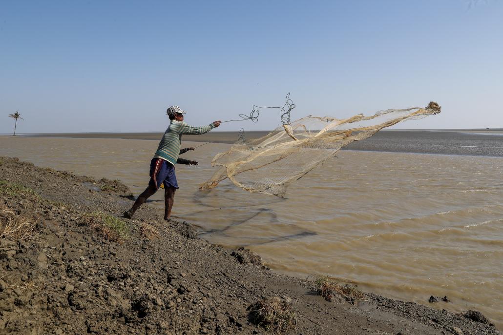 A fisherman throws his net into the Gulf of Mottama where the village of Ta Dar U stood until just a few years ago.