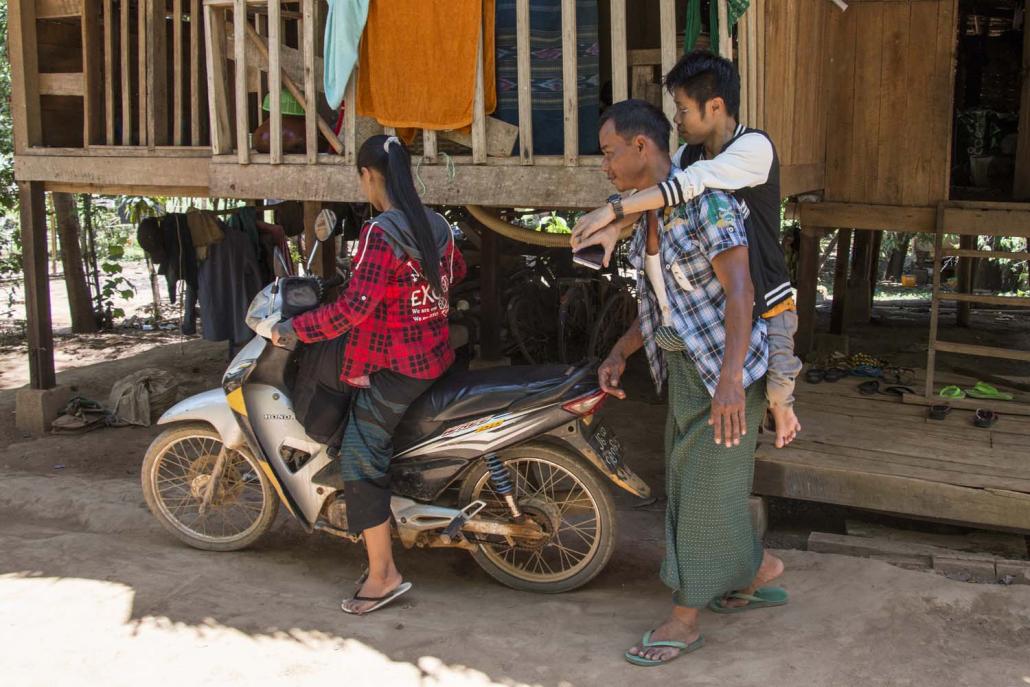 A man carries Ko Kan Htoo Aung to a motorbike so he can visit a patient. (Nyein Su Wai Kyaw Soe | Frontier)