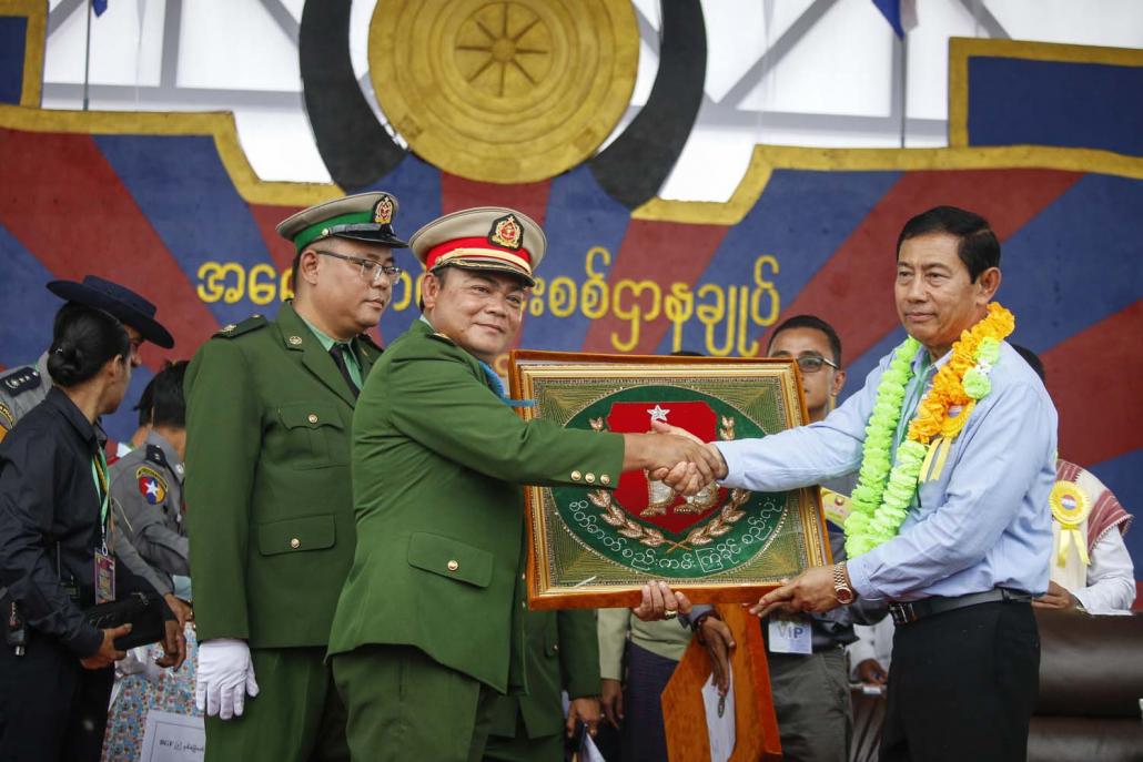 Union Solidarity and Development Party chair U Than Htay (right) presents a souvenir to Colonel Saw Chit Thu. (Nyein Su Wai Kyaw Soe | Frontier)