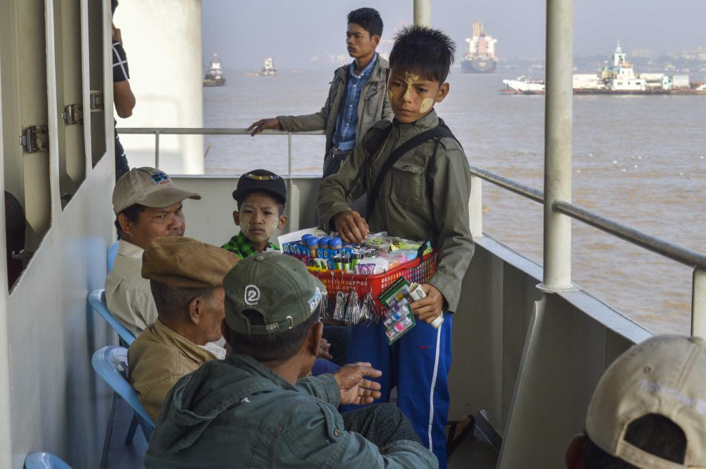 A young boy sells snacks on a ferry on the Yangon River. (Nyein Su Wai Kyaw Soe | Frontier)