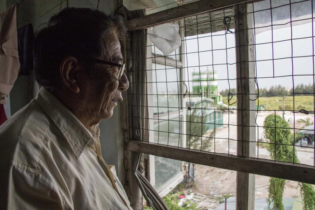 U Maung Maung Lwin, 79, looks out his window towards the Tet Lann Concrete factory. (Nyein Su Wai Kyaw Soe | Frontier)