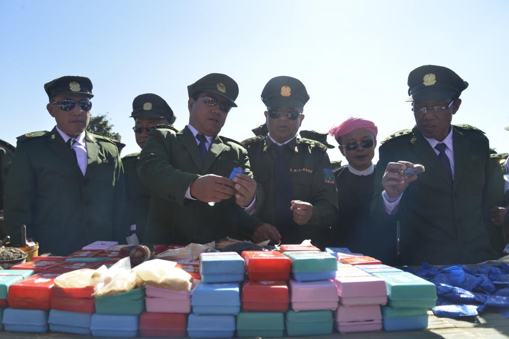 Members of the TNLA central committee inspect grade 4 heroin and yaba pills seized from Pansay militiamen. (Niels Larsen / Frontier)