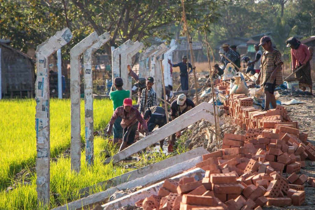 Workers build a fence to enclose more than 200 acres of farmland in South Dagon Township on February 4. (Thuya Zaw | Frontier)