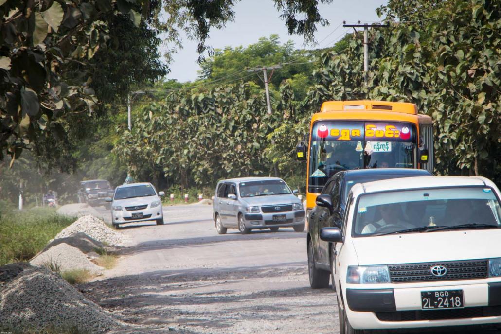 Traffic on the narrow and rutted highway connecting Yangon with Pathein, run by Oriental Highway Co under BOT terms for a decade. (Thuya Zaw | Frontier)