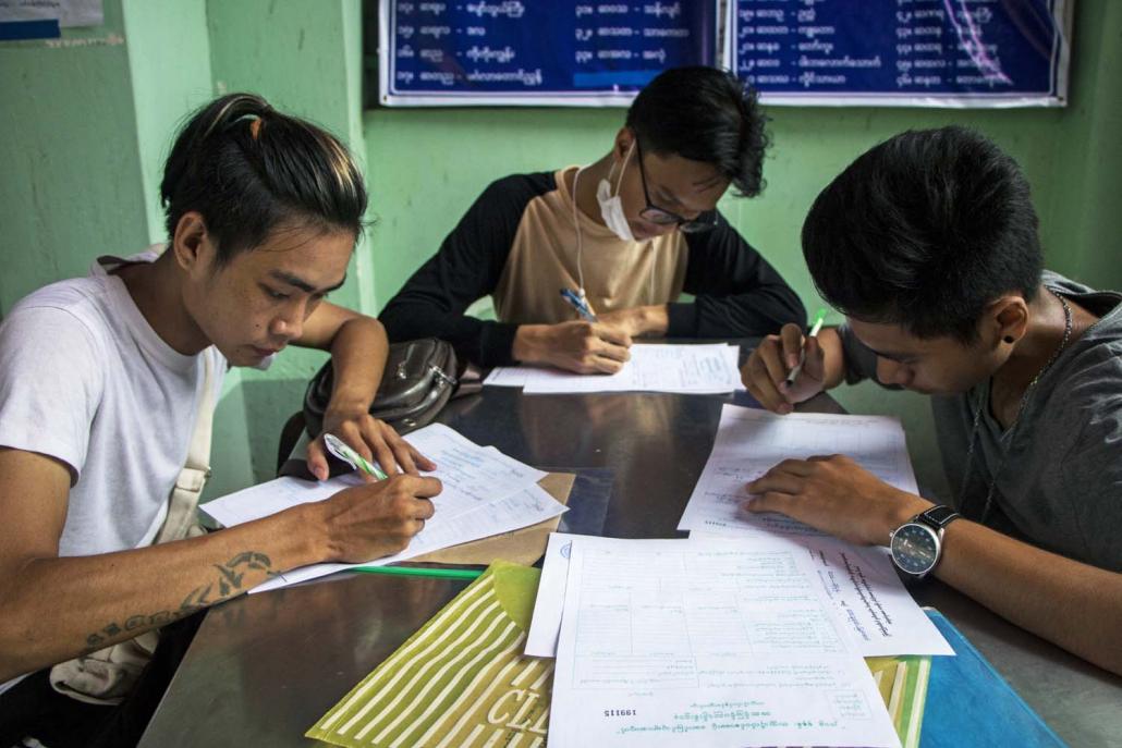 Students who passed the matriculation exam fill in the university admission form at Yangon University in Kamaryut Township on June 27. (Thuya Zaw | Frontier)
