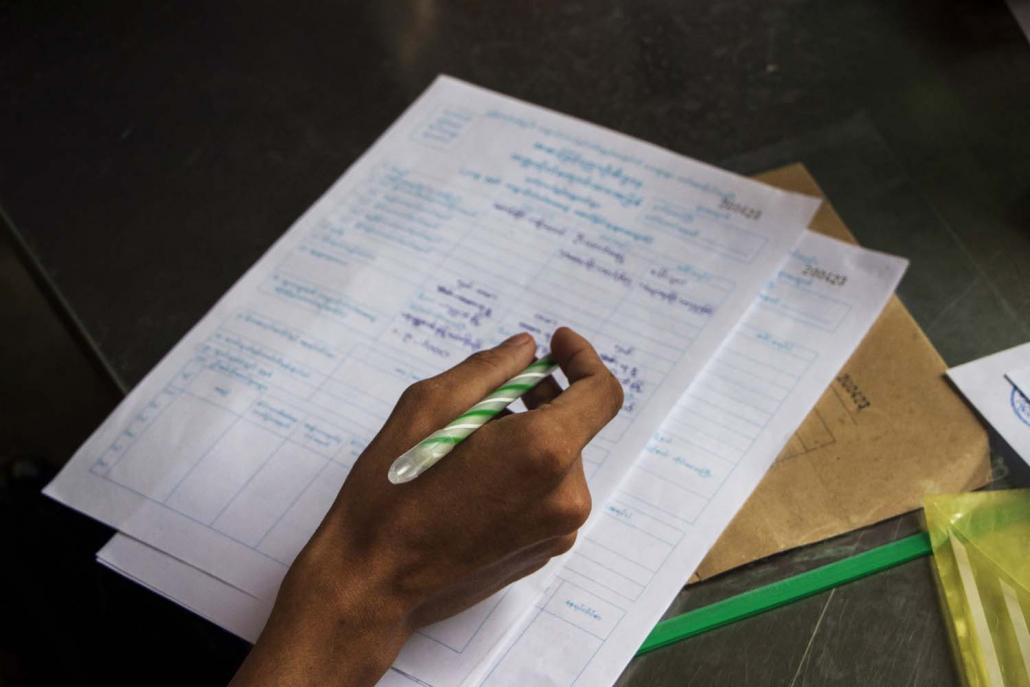 Students who passed the matriculation exam fill in the university admission form at Yangon University in Kamaryut Township on June 27. (Thuya Zaw | Frontier)